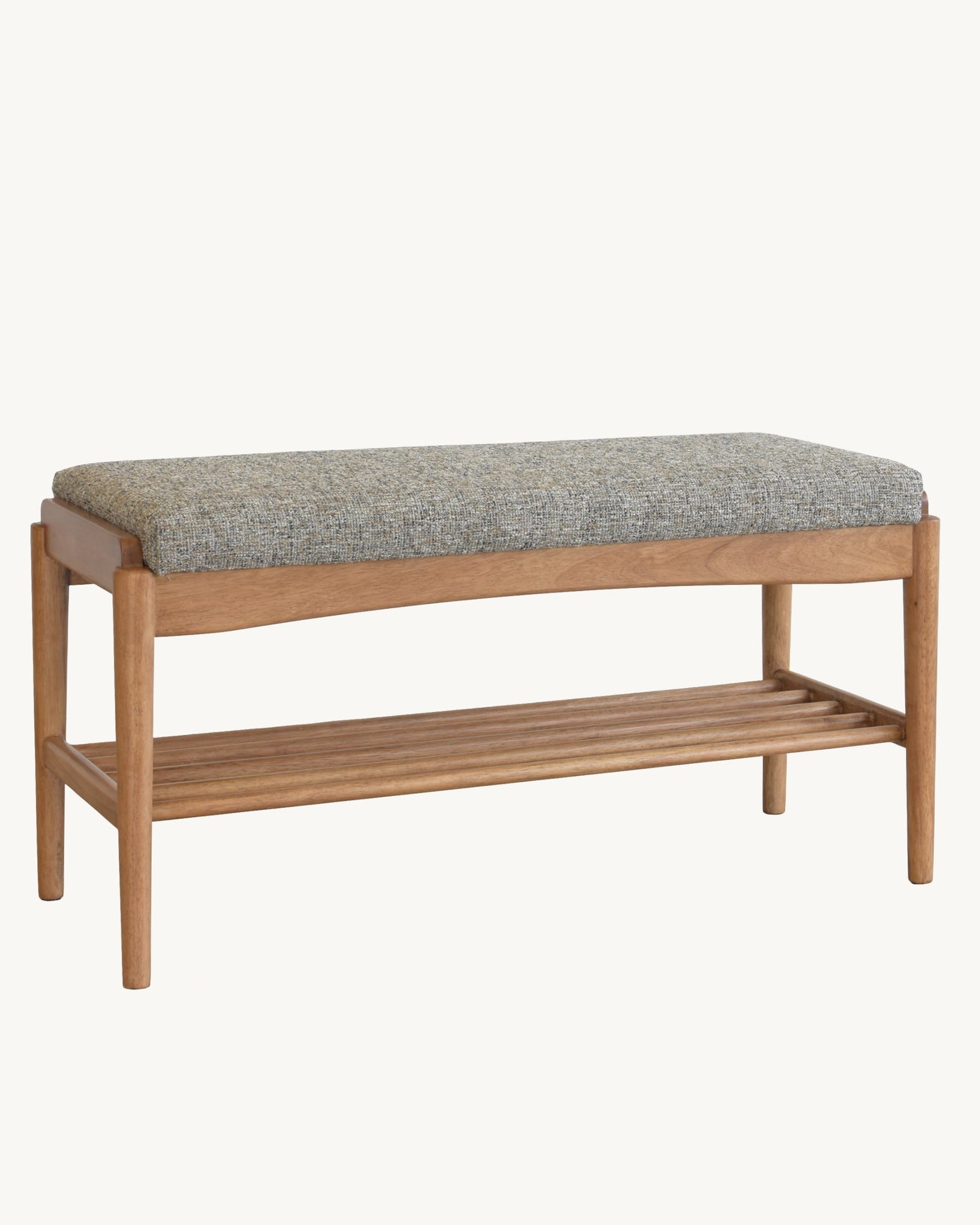 A wooden bench with a gray textured cushioned seat and a slatted lower shelf, shown against a plain off-white background.